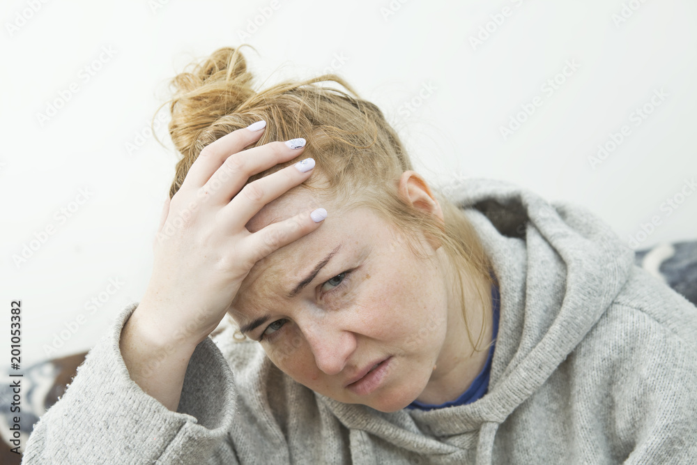 Young woman with headache lying on couch at home, casual style indoor shoot Young woman with headache lying on couch at home, casual style indoor shoot