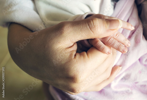 Baby holding mother s hand. The concept of care  and tenderness of motherhood. Closeup 