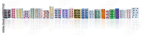 Slika na platnu Many of colorful pills in blister packs in a row isolated on white background with copy space