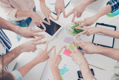 Cropped, top high angle view close up portrait of students hands showing putting v-signs in circle in workstation, harmony, motivation, inspiration, connection, achievement, organization concept