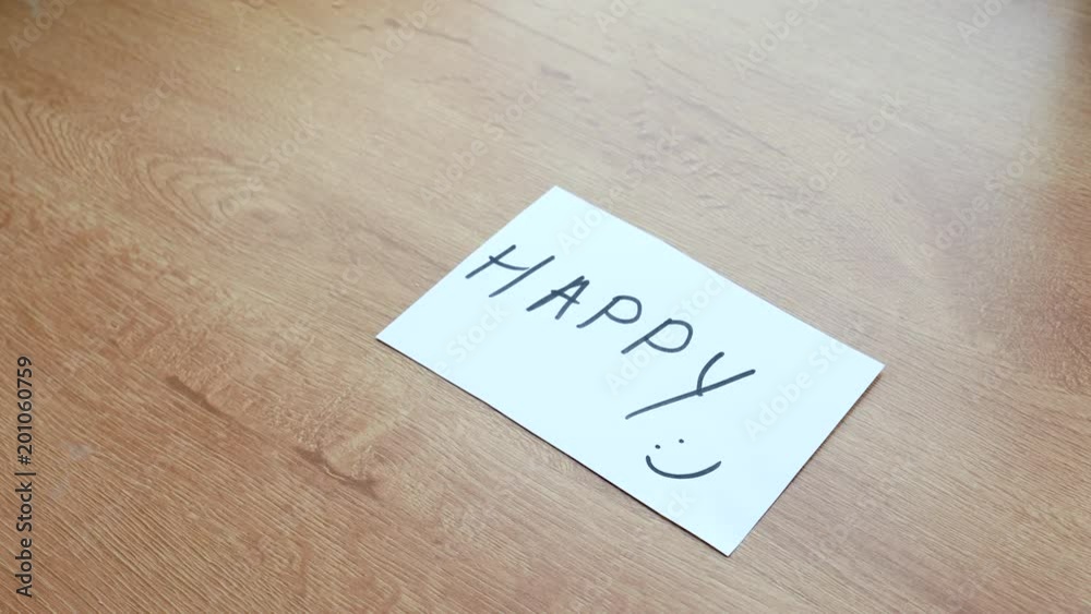 The word writen on the paper unhappy made as happy The word writen on the paper unhappy made as happy