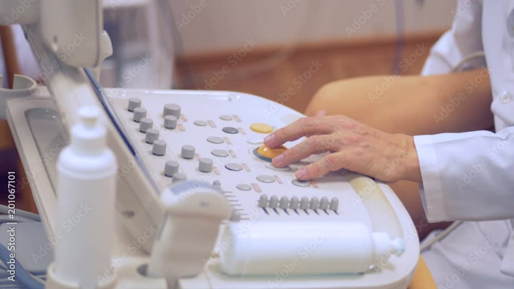 Close up of doctor's hand manipulating round joystick of an ultrasound console Close up of doctor's hand manipulating round joystick of an ultrasound console