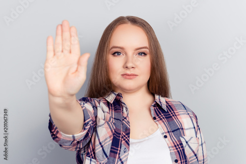 Young woman holds her hand out in stop gesture