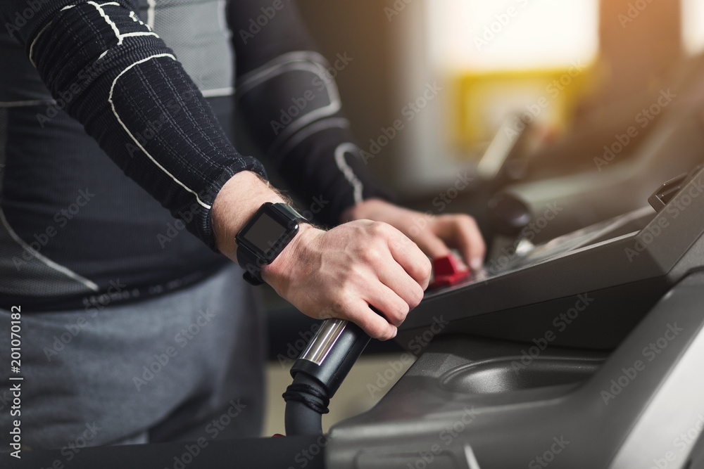Unrecognizable man in gym running on treadmill Unrecognizable man in gym running on treadmill