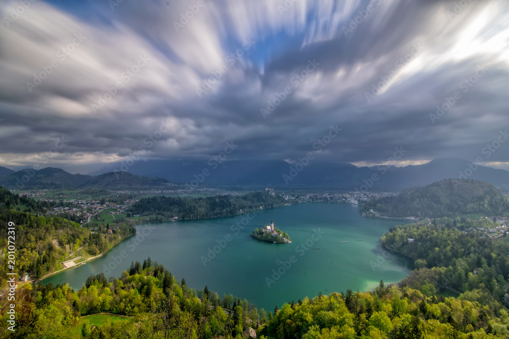 Scenic panoramic view of Lake Bled from above with moving clouds