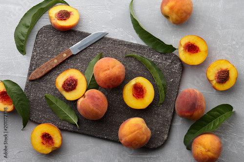 Fresh peaches fruits with leaves on textured stone background  top view