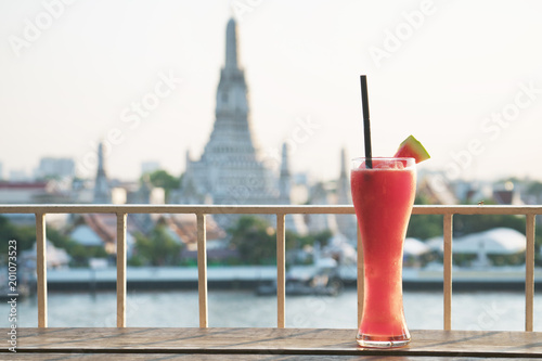 Photography Watermelon on wooden floor,blurred background of Wat Arun, Bangkok, Thailand