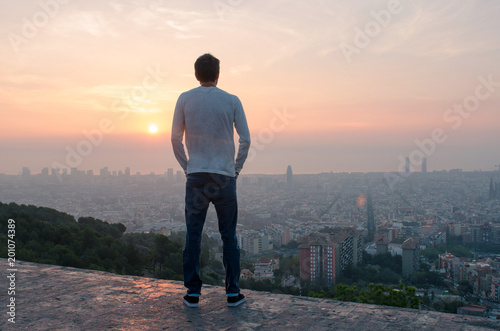 Photography Chico mirando el skyline de la ciudad de Barcelona al amanecer