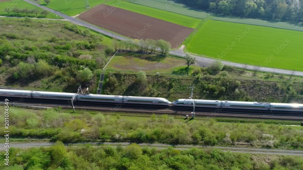 Highspeed train on railroad track, tunnel entrance - aerial view