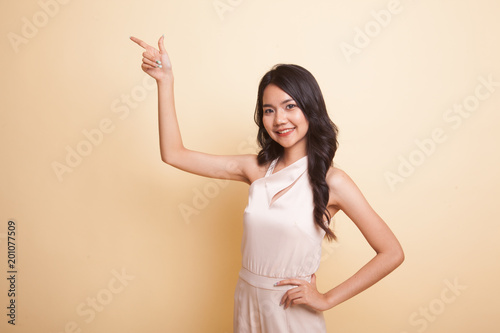 Young Asian woman smile and point.