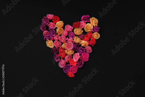 Mix of pink and Peach Fake Plastic Mini rosess Flowers Black Background copy space. Craft, Art, Hobby concept. photo