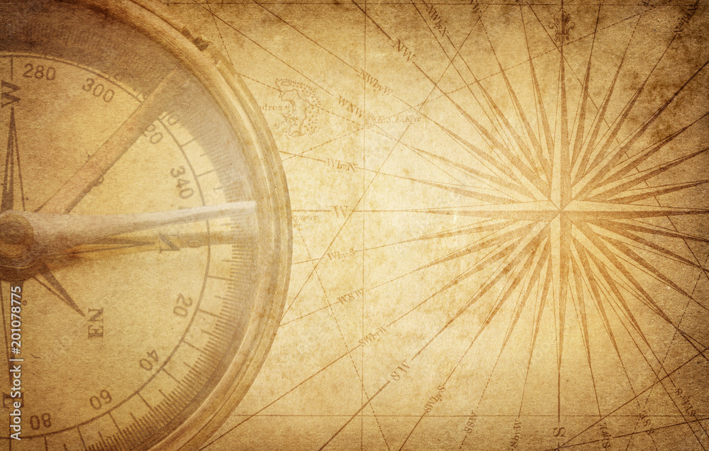 Obraz premium Old vintage retro compass on ancient map. Survival, exploration and nautical theme grunge background