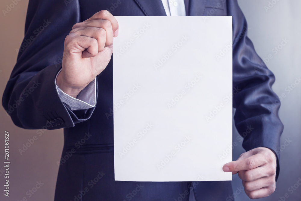 mock up in businessman's hand. male holding blank sheet of paper. young man in suit shows white card. Area for advertising. Copy space mock up in businessman's hand. male holding blank sheet of paper. young man in suit shows white card. Area for advertising. Copy space