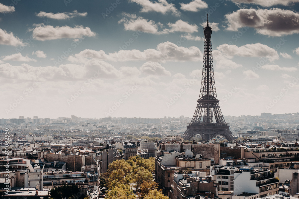 Outdoor horizontal shot of wonderful Eiffel towel in Paris. Nice city with its landmarks and places of interest. Blue sky with white clouds. Panoramic view of capital of France. French style