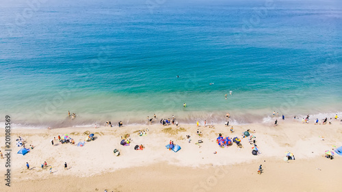 Aerial view of sandy beach with tourists swimming in beautiful clear sea water © yaophotograph