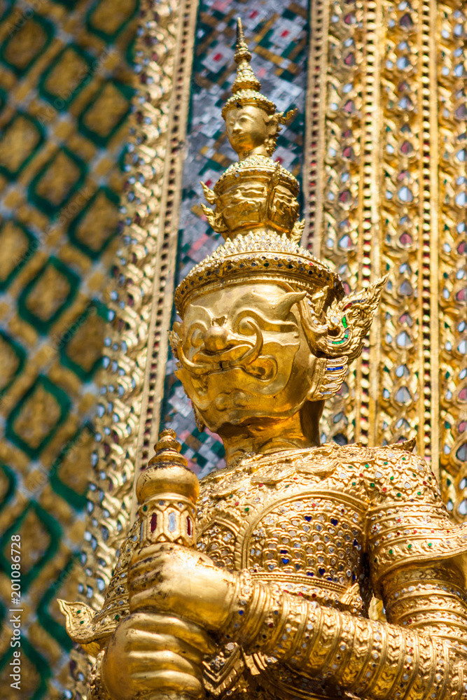 Golden statue at the Wat Phra Kaew Palace, also known as the Emerald Buddha Temple. Bangkok, Thailand.