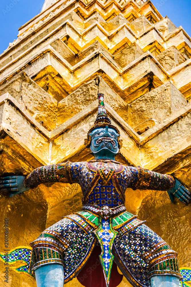 Fototapeta premium Statue of demon holding up the Golden chedi at the Wat Phra Kaew Palace, also known as the Emerald Buddha Temple. Bangkok, Thailand.