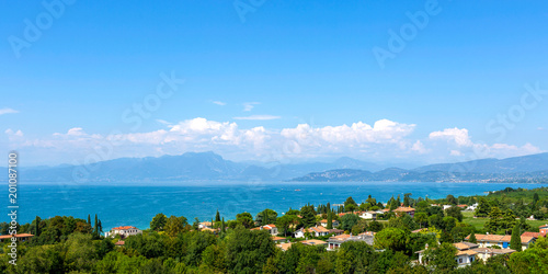 View of Lake Garda, summer landscape. Blue lake, mountayns Alps.  Castelnuovo del Garda, Italy - Agust 31 2016: Gardaland Theme Amusement Park in Castelnuovo Del Garda, Verona, Italy.. photo