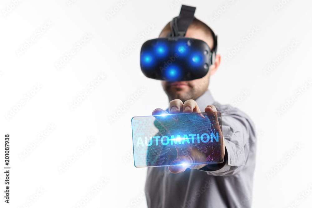 Fototapeta premium Business, Technology, Internet and network concept. Young businessman working in virtual reality glasses sees the inscription: Automation