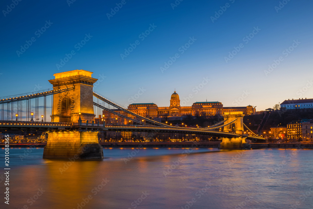 Budapest, Hungary - Illuminated Szechenyi Chain Bridge over River Danube and Buda Castle Royal Palace at blue hour with clear blue sky