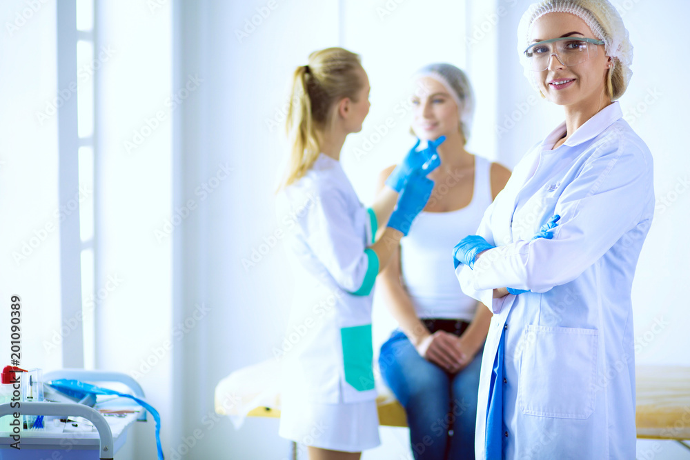 Fototapeta premium Beautiful woman face near doctor with syringe