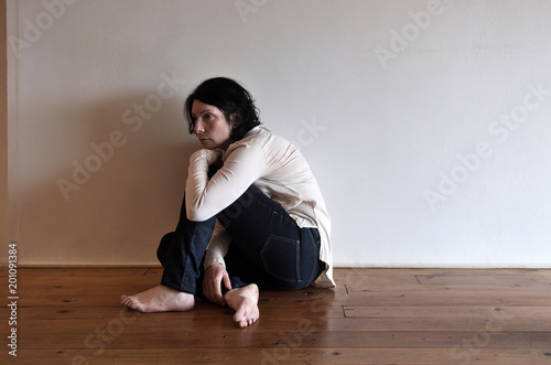 a sad woman on the floor of her house