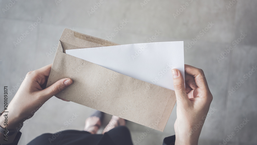 Stand up woman holding white folded a4 paper and brown envelope - obrazy, fototapety, plakaty 