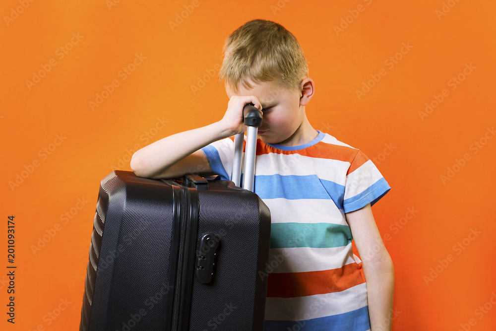 cute boy with a suitcase on a bright orange background cute boy with a suitcase on a bright orange background