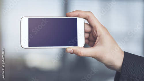 Woman holding and showing mobile phone