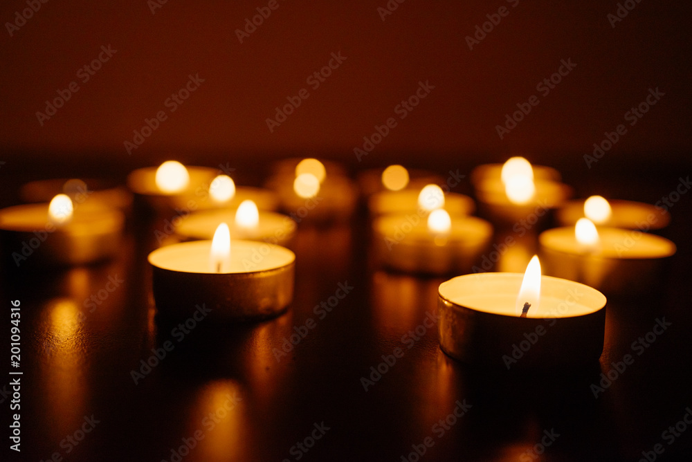 Burning candles. Shallow depth of field. Many christmas candles burning at night. Abstract candles background. Many candle flames glowing on dark background. Close-up. Free space.