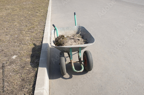 Wheelbarrow with garbage, cleaning of the territory photo