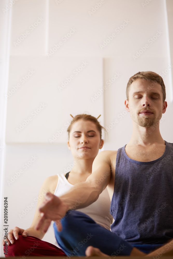 Young healthy couple in yoga position on white background Young healthy couple in yoga position on white background