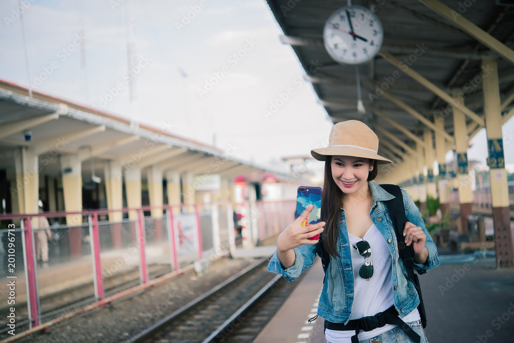 Asian tourist wait train at train station,thailand hipster man go to travel