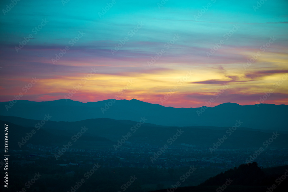 Romantic, bright and colorful sunset over a mountain range in Transilvania. Beautiful, colorful autumn background