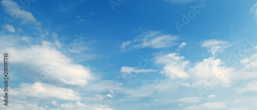Light cumulus clouds in blue sky. Wide photo.