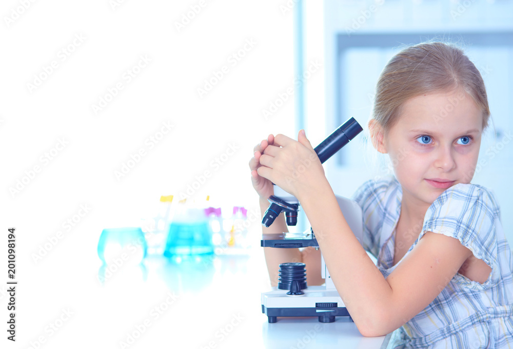 Schoolgirl looking through microscope in science class. Schoolgirl looking through microscope in science class.