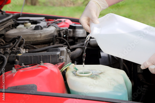 Auto serwis, uzupełnianie płynu do spryskiwaczy.