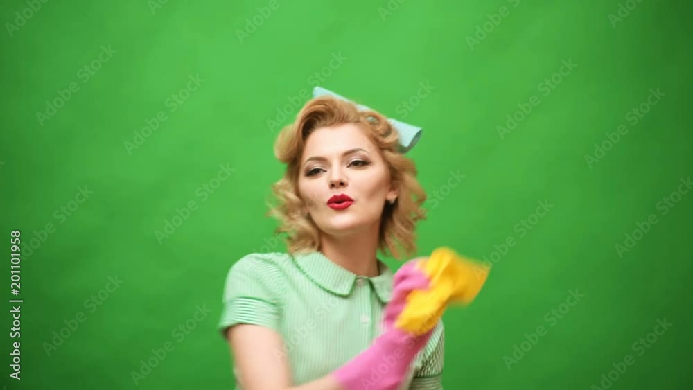 Pin up woman in gloves smiling and wiping dust using a spray and a duster. Cleaning concept with supplies. Beautiful young woman makes cleaning. Pin up cleaning. Beautiful woman in gloves cleaning. Pin up woman in gloves smiling and wiping dust using a spray and a duster. Cleaning concept with supplies. Beautiful young woman makes cleaning. Pin up cleaning. Beautiful woman in gloves cleaning.