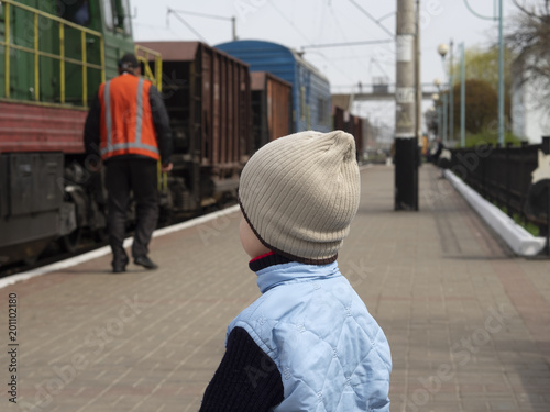 boy looks at a railwayman