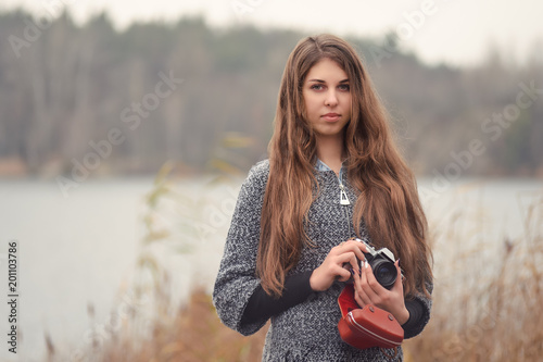 Girl photographer with an old camera on the lake photo