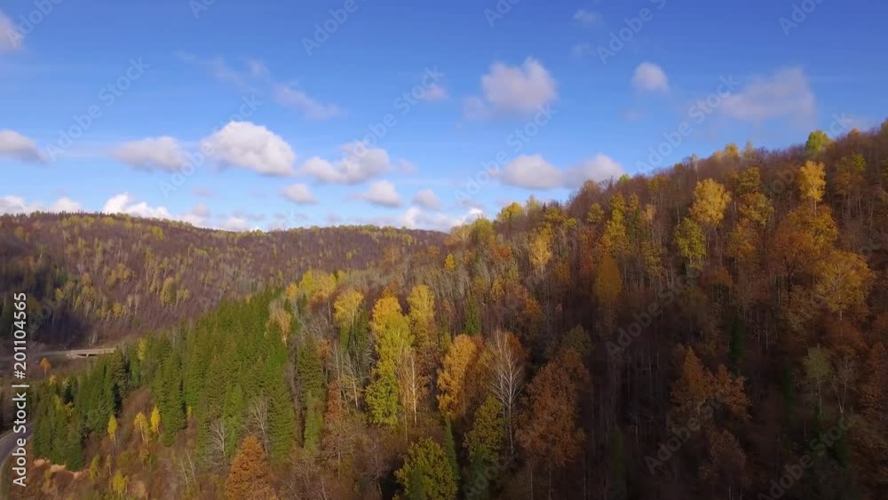 Car goes down the mountainside along the river \ the car goes on autumn road aerial view top Car goes down the mountainside along the river \ the car goes on autumn road aerial view top