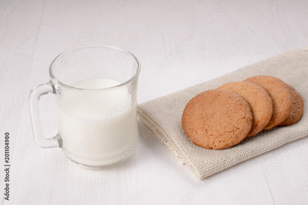 Homemade ginger cookies with a glass of milk on a wooden light b Homemade ginger cookies with a glass of milk on a wooden light b