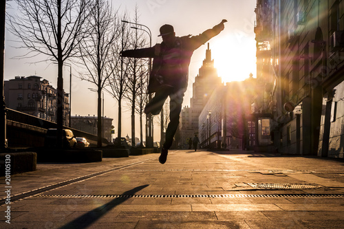 mun in the city street jumping during sunset success concept