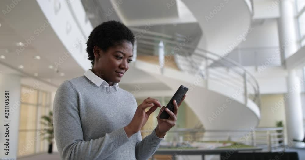 African American using smartphone in modern office