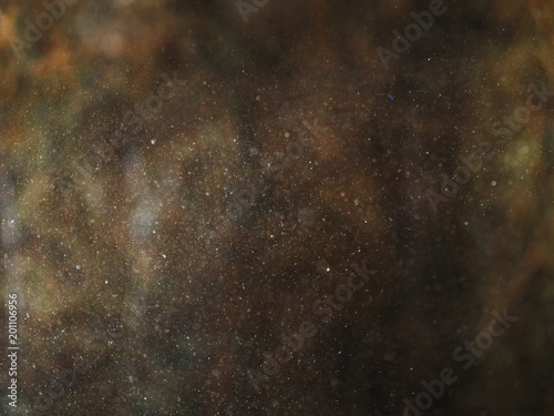 Tiny dust particles in a sunlight on a dark natural background.  Abstract lighting photo