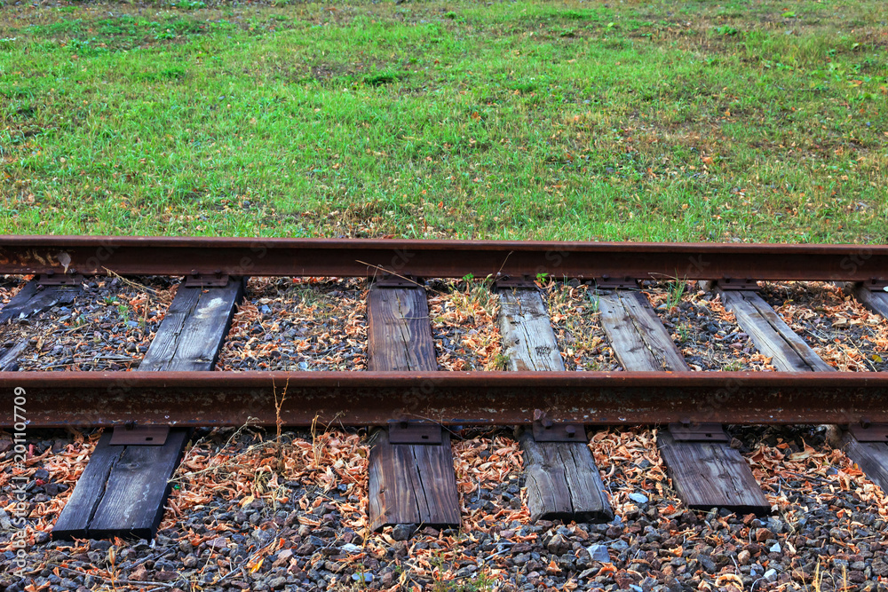 Old abandoned railway track with wooden sleepers in the forest among trees, Old abandoned railway track with wooden sleepers in the forest among trees,
