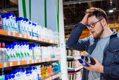 man can't decide in store what to buy. shopping concept. copy space photo