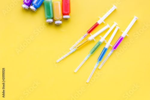 Medical injection Syringe and bottle with remedy on yellow background top view copy space