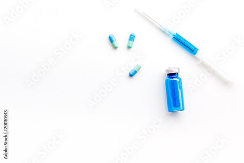 Medical therapy. Syringe, bottle with drug, pills on white background top view copy space