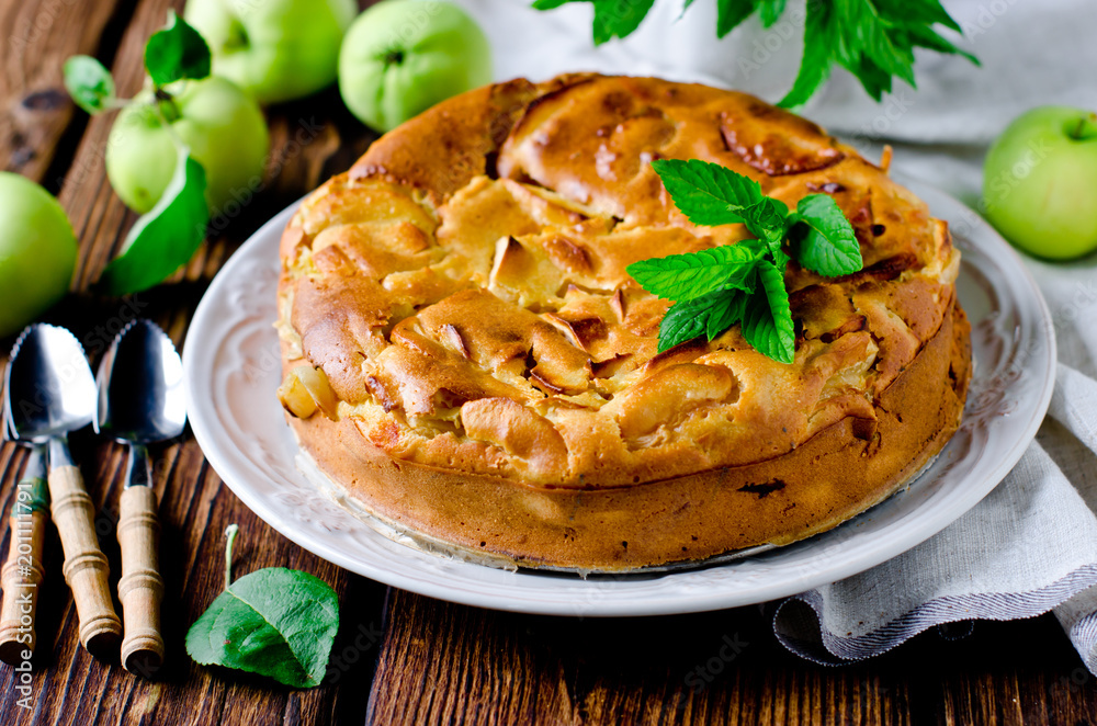 Apple cake on the plate on a wooden table